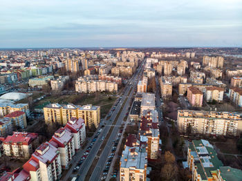 High angle view of city buildings against cloudy sky