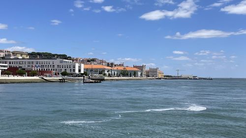Buildings by sea against sky