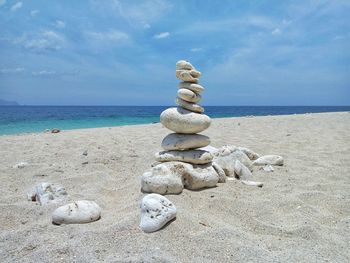 Stack of pebbles on beach against sky