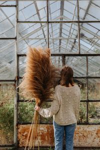 Rear view of woman standing against built structure