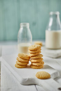 Cookies by milk in bottle on table