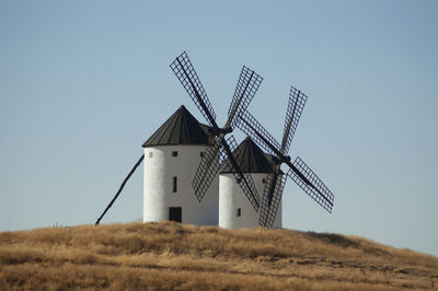 Low angle view of windmill on field against sky