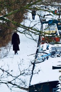 Rear view of woman on snow covered tree