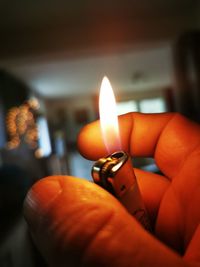 Close-up of hand holding lit candle