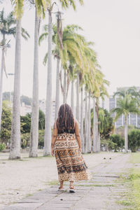 Rear view of woman walking with umbrella