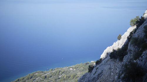 Scenic view of sea and mountains against blue sky