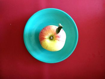 High angle view of apple on table against red background