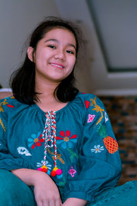 Portrait of a smiling young woman sitting at home