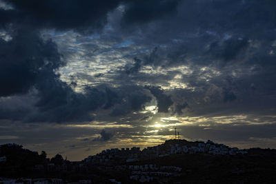 Scenic view of dramatic sky over city during sunset