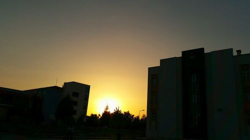 Silhouette of buildings against sky at sunset