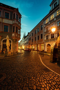 Street amidst buildings against sky at night