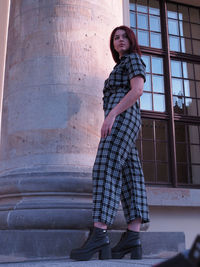 Portrait of woman standing against building