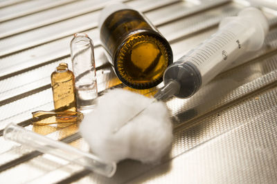 Close-up of syringe with cotton on table