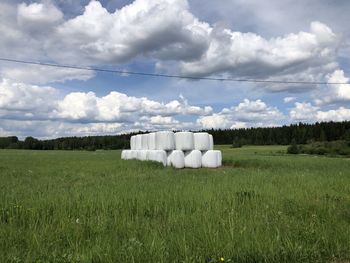 Hay bales on field against sky