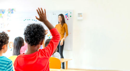 Boy raising hand in classroom