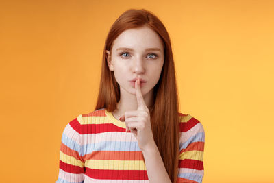 Portrait of mid adult woman against yellow background