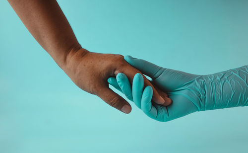 Close-up of hands over blue background