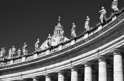 Low angle view of st. peters cathedral against clear sky with statues