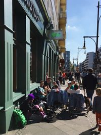 People on street in city against sky