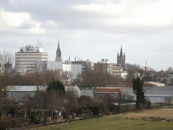 View of cityscape against cloudy sky