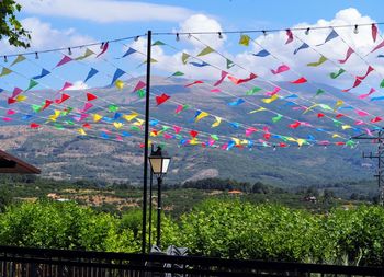 Multi colored flags on landscape against sky. fiestas locales
