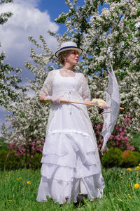 Portrait of young woman standing on grassy field