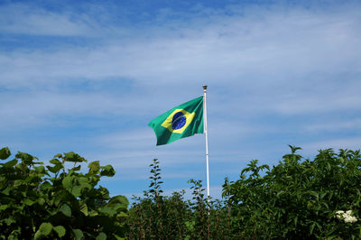 Low angle view of brazilian flag against blue sky