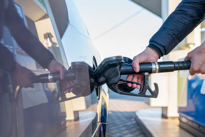 Midsection of man refueling car