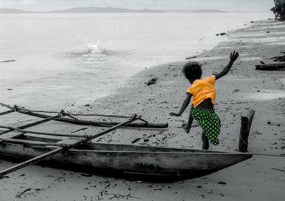 Rear view of woman standing by sea