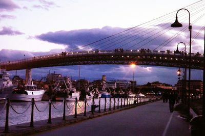 Bridge over river against cloudy sky