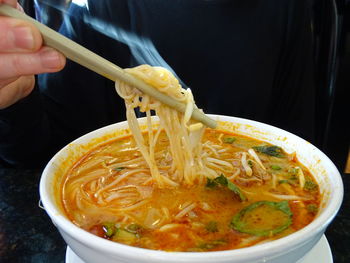 Close-up of person holding soup in bowl