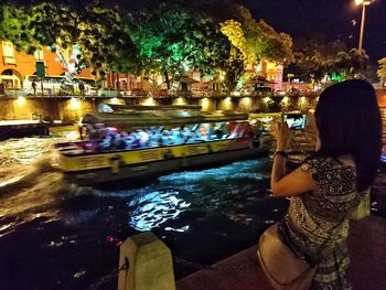 Reflection of people in water at night