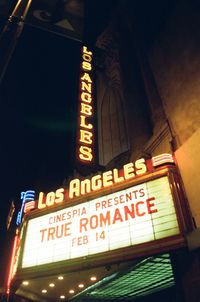 Low angle view of illuminated sign at night