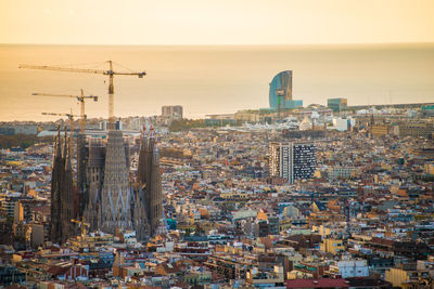 Aerial view of sagrada familia amidst buildings during sunset