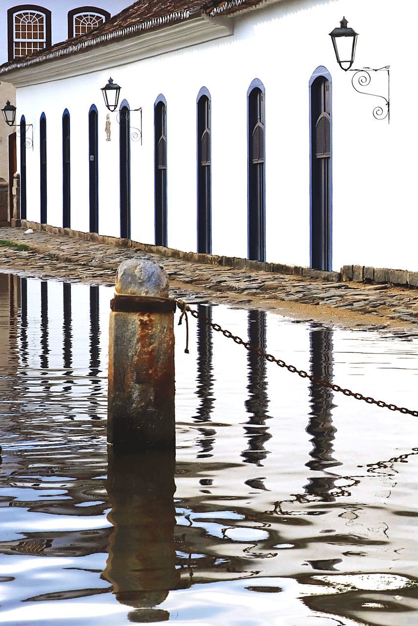 water, reflection, architecture, built structure, waterfront, day, building exterior, no people, nature, building, post, outdoors, architectural column, lake, rippled, connection, in a row, sky, wood - material, wooden post