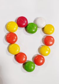 High angle view of multi colored candies on white background
