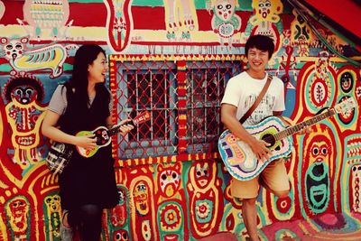 Two young people playing guitars