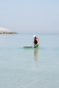 Man doing e foiling around people paddle boarding