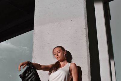 Portrait of woman standing against window