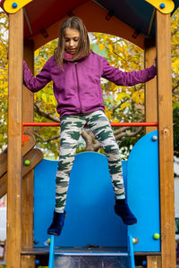 Full length of girl sitting on jungle gym