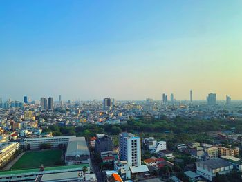 Aerial view of buildings in city against clear sky