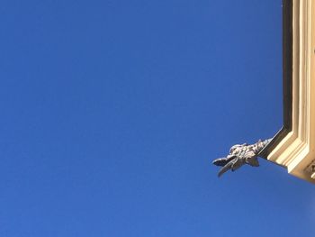 Low angle view of statue against blue sky