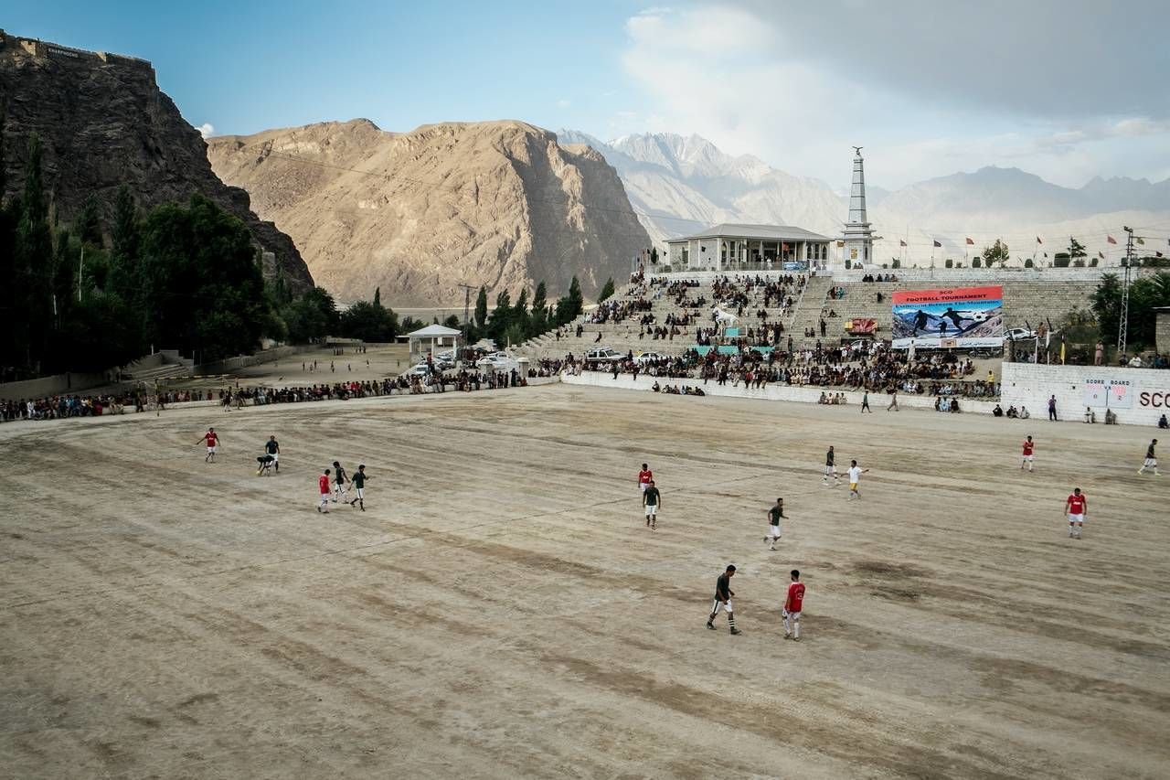 group of people, mountain, sport, real people, sky, playing, day, crowd, leisure activity, large group of people, men, team sport, nature, lifestyles, playing field, soccer, cloud - sky, land, mountain range, outdoors