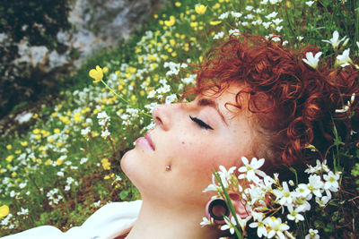 Close-up of young woman lying on field at park