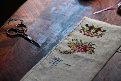High angle view of fabric with scissor on table