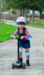 Child riding push scooter in a park