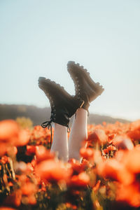 Midsection of woman with arms raised against clear sky