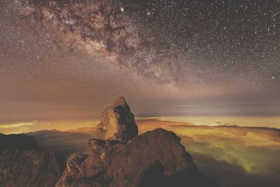 Scenic view of rock against sky at night