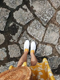 Low section of woman standing on footpath