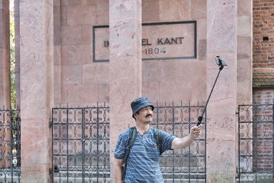 Senior asian tourist with backpack taking selfie in front of grave of philosopher immanuel kant 